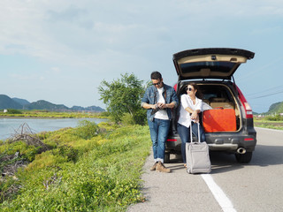 Happy Asian couple enjoying roadtrip with nature background, lifestyle concept.