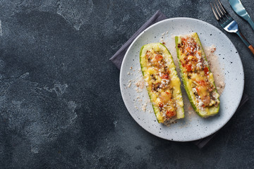 Baked stuffed zucchini boats with minced chicken mushrooms and vegetables with cheese on a plate. Copy space