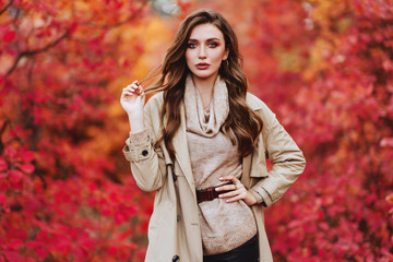 Fashion woman on a background of red and yellow autumn leaves