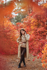 Fashion woman on a background of red and yellow autumn leaves