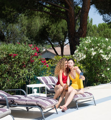 two women with swimsuits and taking selfies