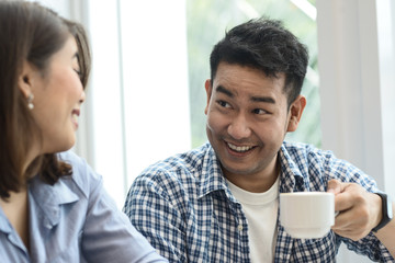 Cheerful Asian couple drinking coffee together in cafe, lifestyle concept.