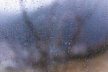 Raindrops on window glass with blur background