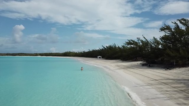 Fast Drone footage over sandy beach and beautiful turquoise water on Bahamas island Half Moon Cay in the morning