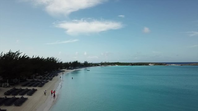 Drone video flying over busy beach Bahamas island 
Half Moon Cay in the moring
