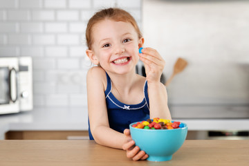 Smiling little girl holding candy in hand