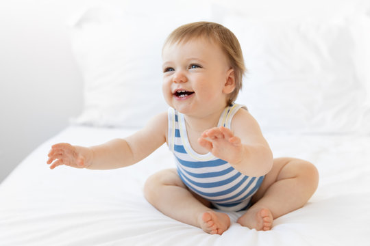 Laughing baby boy reaching out with arms extended