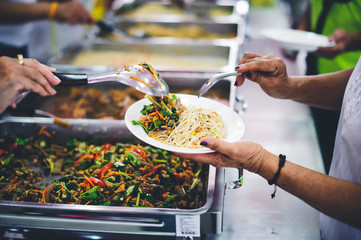 Giving food to the poor, the hands of beggars receive charity food from service providers: concept...