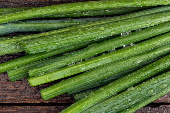 Green onions on wooden table. Bunch of onions batun ready for cooking. Healthy eating and vegetarianism.