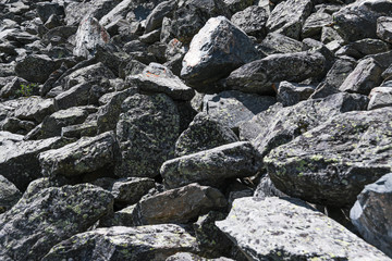 Dump of stones for construction. Stone quarry with boulders. Mountain moraine,  barrier to tourist.