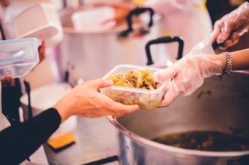 Helping fellow human beings in society by donating food to starving people : concept of sharing, giving hope
