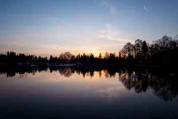 暁の湖畔に細い月が湖面に映る