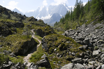 Trekking trail in mountains. Journey to snowy cliffs. The path to goal.