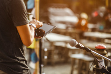 Close-up of musicians the singer is checking the sound with a tablet to prepare an outdoor concert. Music Concepts