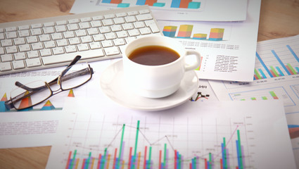 Laptop with stack of folders on table on white background