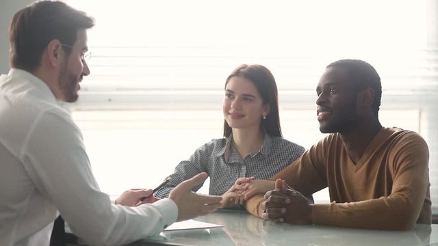 Happy diverse couple sign contract making financial deal