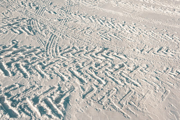 Tire tracks on winter road. Frozen road, transportation in snow.