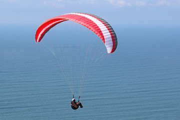 Paraglider flying above the sea