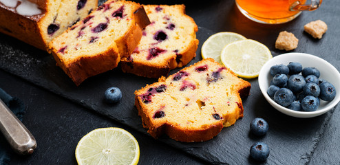 Homemade Blueberry Lemon Cake on black stone background.