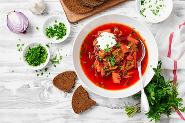 Beetroot soup - Traditional Ukrainian or Russian borscht with sour cream in a white bowl.