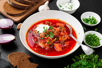Beetroot soup - Traditional Ukrainian or Russian borscht with sour cream in a white bowl.