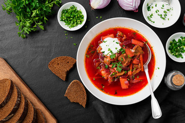 Beetroot soup - Traditional Ukrainian or Russian borscht with sour cream in a white bowl.