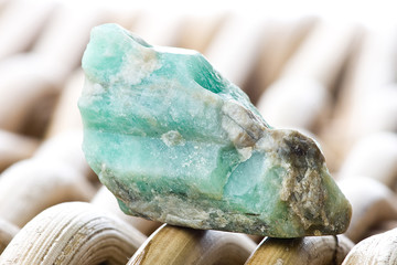 Macro photography of an emerald stone on a wicker background