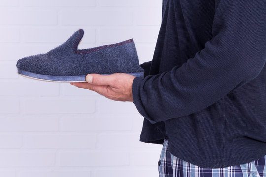 Man In Pajamas Holding House Slippers