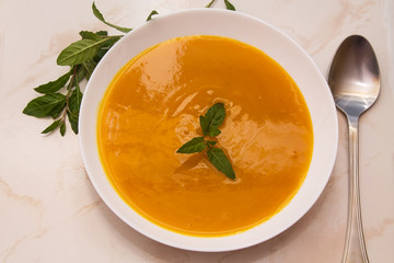 bowl with pumpkin soup on background