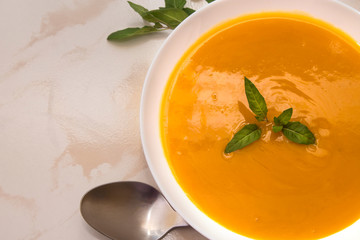 bowl with pumpkin soup on background