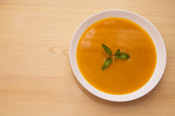 bowl with pumpkin soup on background
