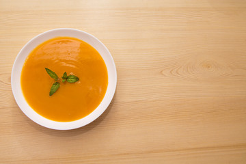 bowl with pumpkin soup on background