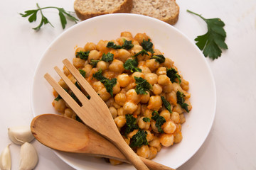 bowl of cooked chickpeas with spinach closeup view