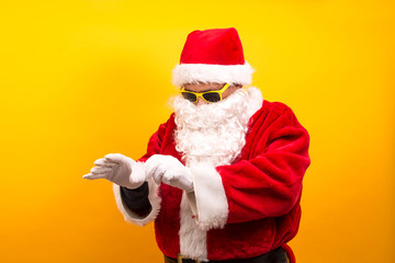 portrait of santa claus with sunglasses on yellow background