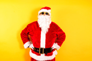 portrait of santa claus with sunglasses on yellow background