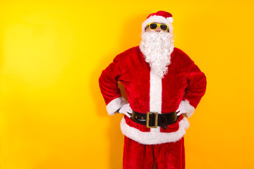 portrait of santa claus with sunglasses on yellow background