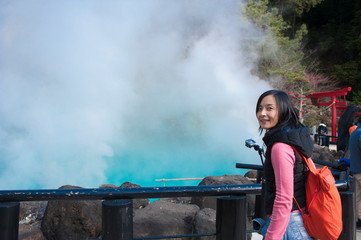 Asian tourist woman takes a photo at Hot spring (Hell) onsen, hot blue water The "sea hell" in Umi Jigoku at Beppu, Oita-shi, Kyushu, Japan