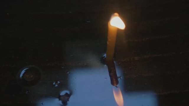 Wax candle and cross on a water surface in a Christian Chapel.