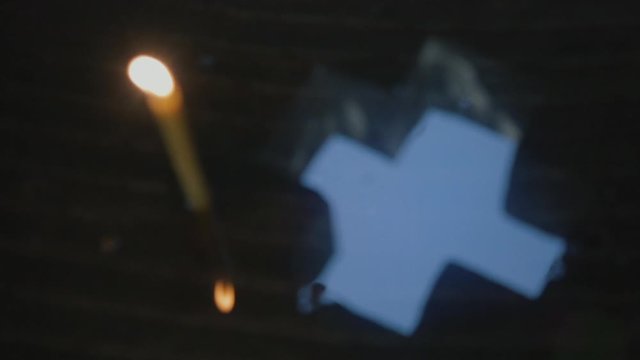 Wax candle and cross on a water surface in a Christian Chapel.