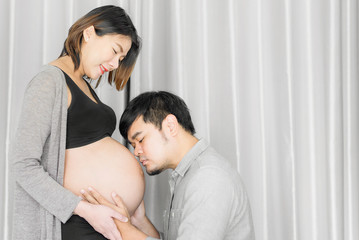 Asian Young pregnant woman with her husband at home , couple expecting a baby