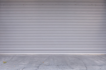 A closeup shot of automatic metal roller door used in factory, storage, garage, and industrial warehouse. The corrugated and foldable metal sheet offer space saving and provide urban and rustic feel