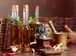 Bottles of olive oil with various spices and vintage cooking utensils.