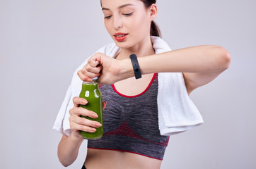 Naklejka premium A girl of beautiful appearance and athletic build opens a can with a healthy drink. Green smoothie of kiwi, cucumber, avocado, chia seeds, vitamin drink. Healthy lifestyle. Sports, gym.