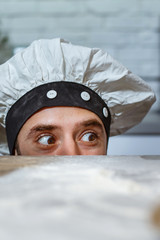 Chef keeps his head on a table in the kitchen with flour.