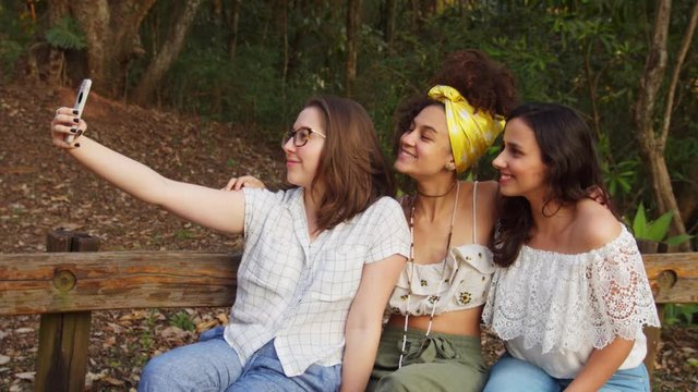 group of girls taking picture in woods, real time medium shot