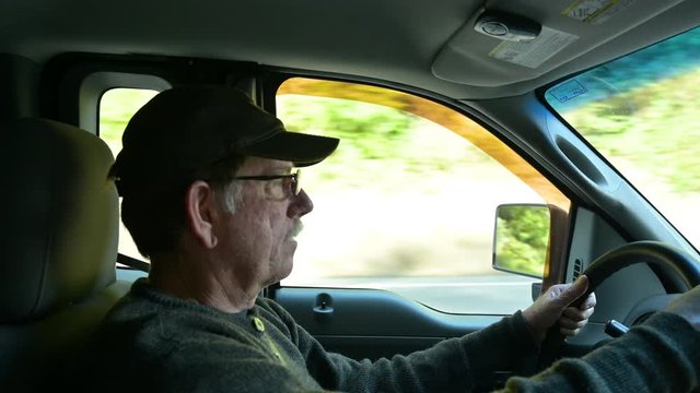 Close up of man driving pickup truck on road