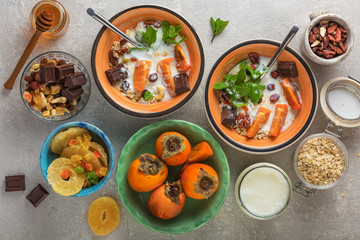 Breakfast ingredients with cereal, yogurt, nuts and fruits. Concrete gray background. Healthy eating