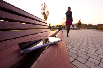 Forgotten smartphone on a park bench.