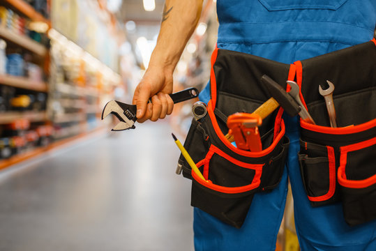 Male builder choosing tool belt in hardware store