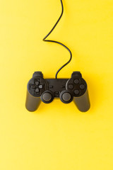 Overhead shot of video game controller on yellow background with copyspace © One Pixel Studio